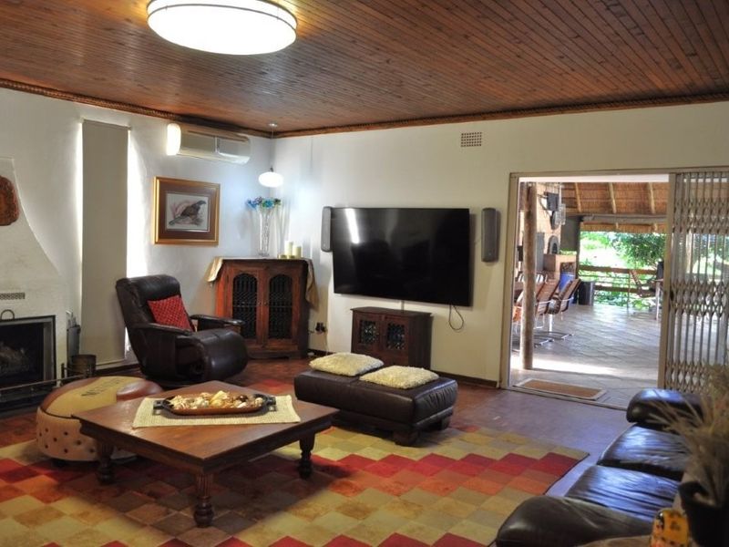 Spacious living room featuring a timber ceiling, fireplace, and direct access to an outdoor patio area through sliding glass doors.