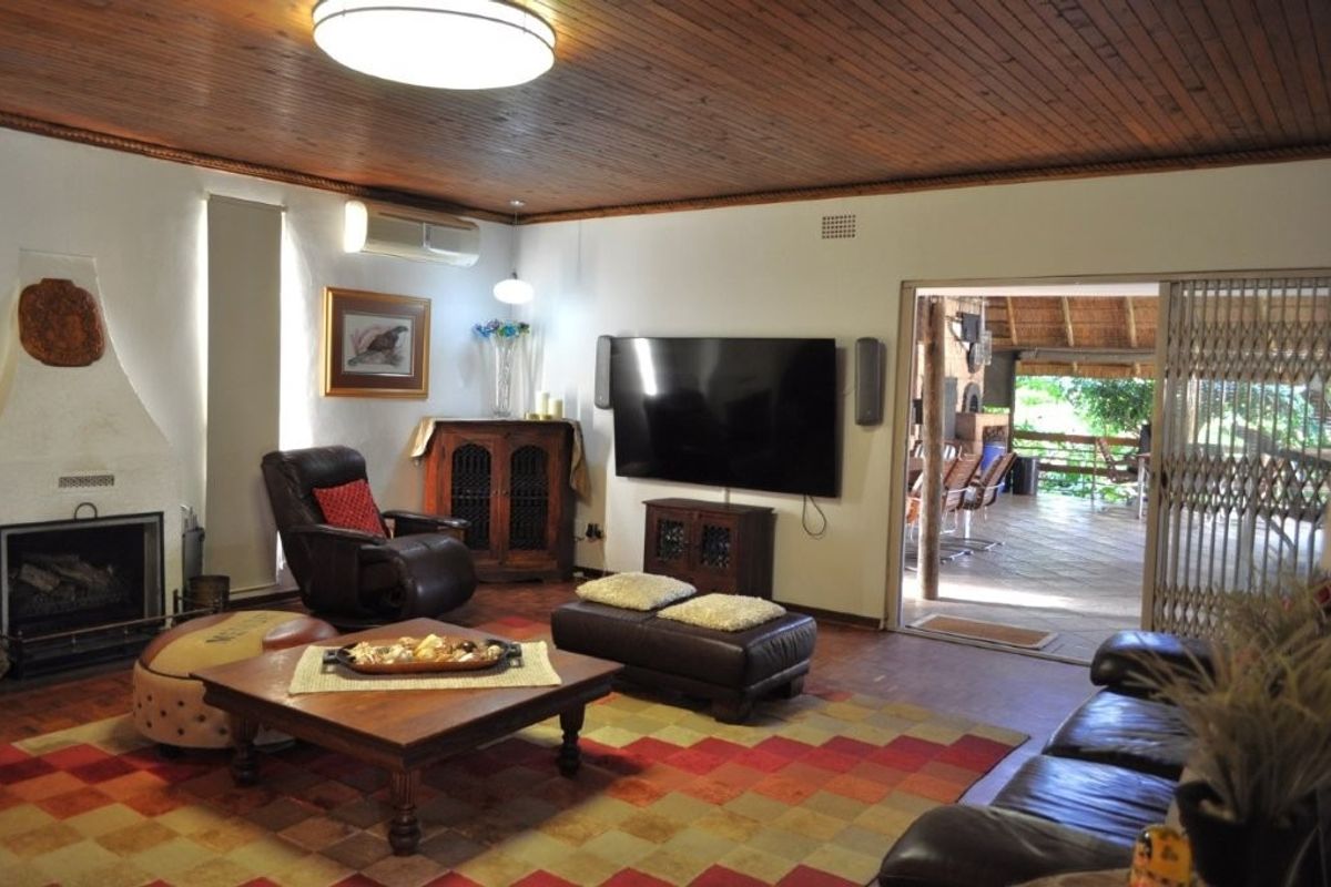 Spacious living room featuring a timber ceiling, fireplace, and direct access to an outdoor patio area through sliding glass doors.