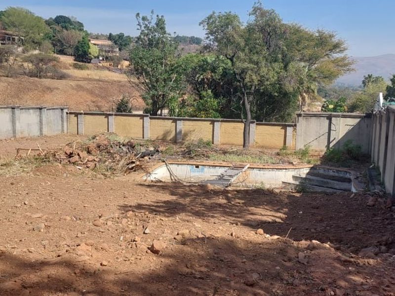 Vacant residential land featuring an existing in-ground swimming pool and perimeter boundary walls, offering a blank canvas for future development.
