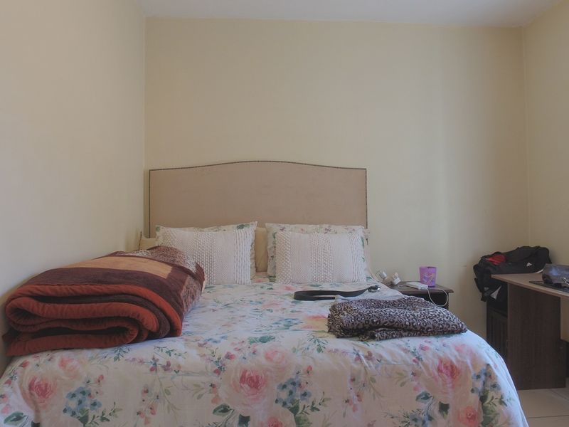 A standard bedroom featuring neutral wall finishes and a curtain rail, providing a functional space for rest.