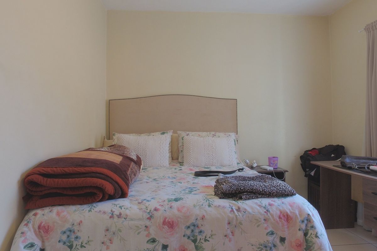 A standard bedroom featuring neutral wall finishes and a curtain rail, providing a functional space for rest.