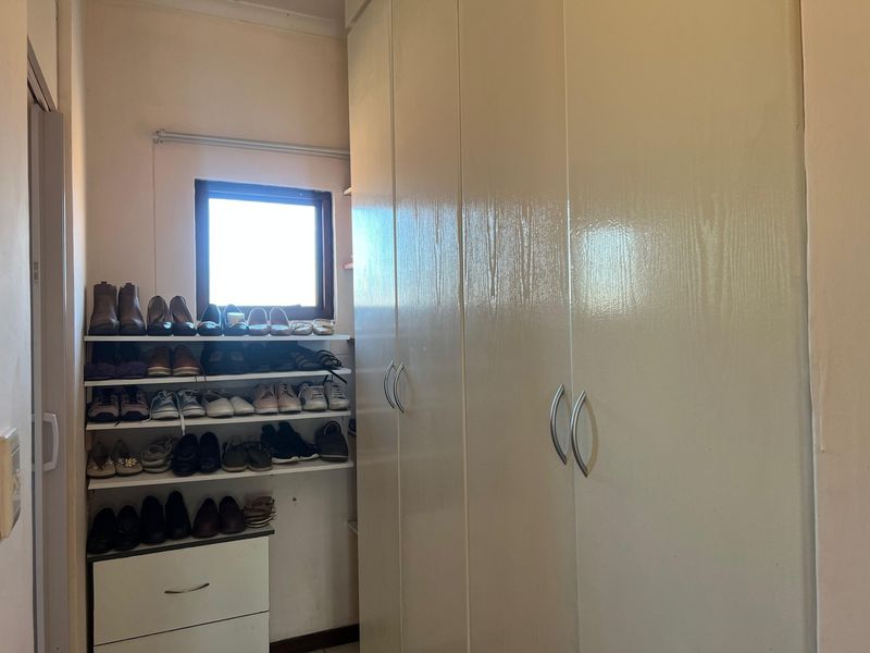 A bedroom featuring extensive built-in cupboard storage and integrated shelving units, providing ample organizational space.