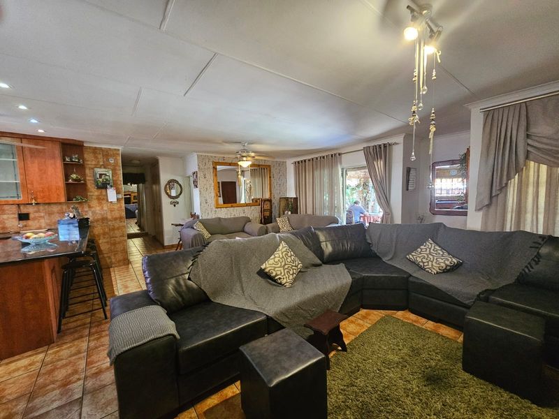 Open-plan living area featuring tiled floors, a functional kitchen with granite countertops, and direct access to the outdoor patio through sliding glass doors.