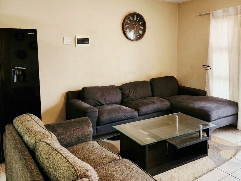 A living room area featuring tiled flooring and a sliding glass door leading to an outdoor space.