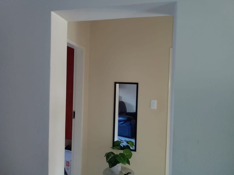 A view through a doorway into a hallway area with neutral wall finishes.