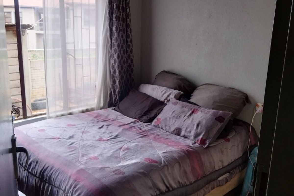 A standard bedroom featuring a window with natural light and direct access to the room.