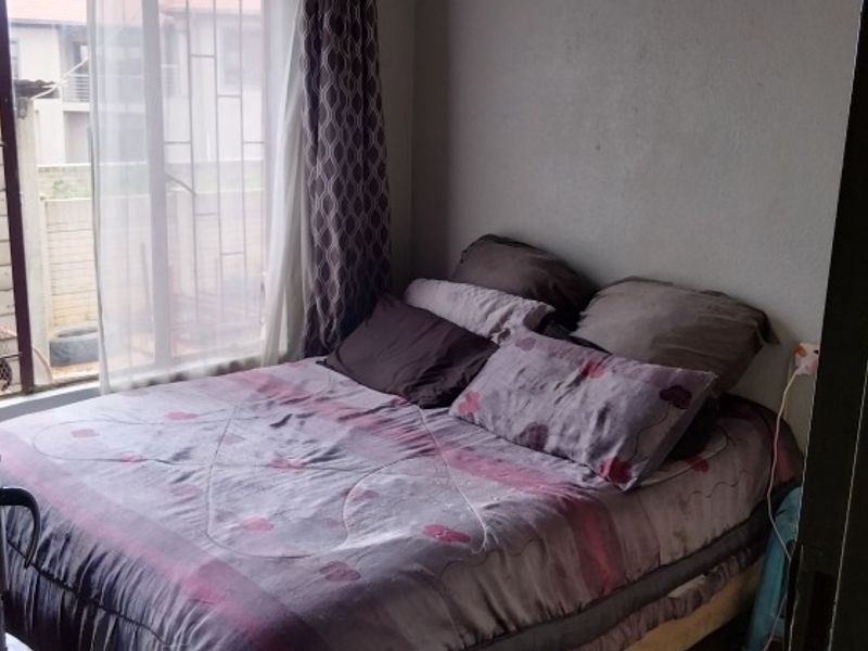 A standard bedroom featuring a window with natural light and direct access to the room.