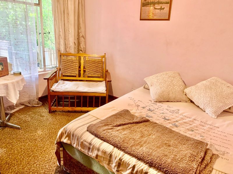 A bedroom featuring carpeted flooring and a window with security bars, requiring cosmetic updates to improve the overall aesthetic.