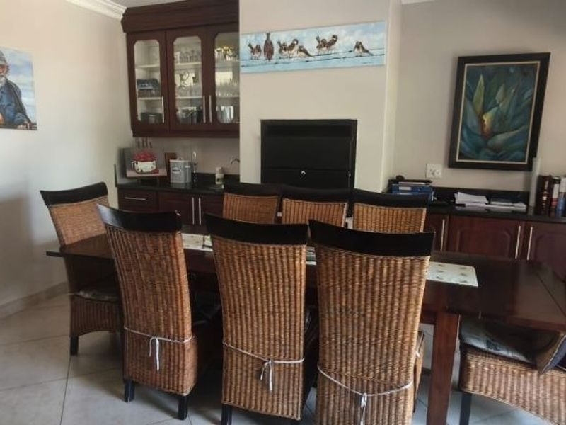 A dining room featuring built-in dark wood cabinetry, a fireplace, and tiled flooring, providing a functional space for meals and storage.