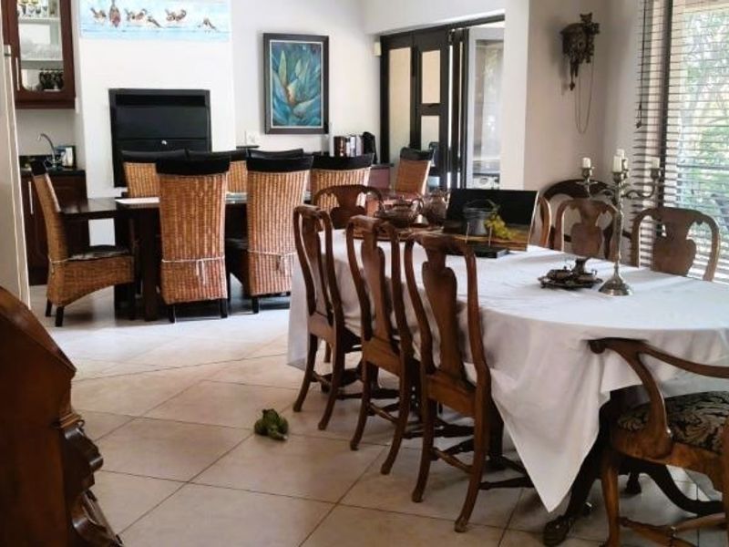 A spacious dining area featuring tiled flooring, a built-in fireplace, and large sliding doors that provide natural light and access to the outdoors.