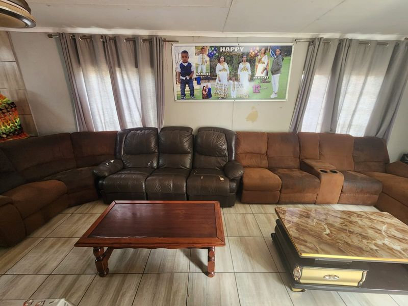 A living room featuring tiled flooring and curtain rods, showing signs of wear on the walls requiring maintenance.