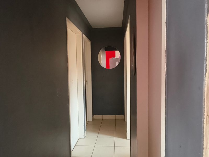 A functional hallway featuring tiled flooring and multiple internal doors, connecting various rooms within the home.