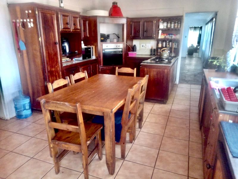 Open-plan kitchen and dining area featuring traditional wooden cabinetry, built-in oven, gas hob, and ceramic floor tiles.
