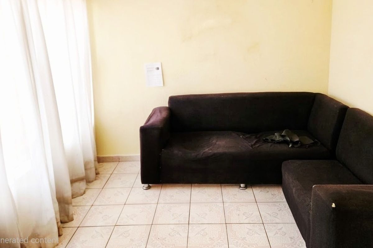 A living room area featuring ceramic floor tiles and plain walls, currently requiring cosmetic updates and fresh paint to improve the overall aesthetic.