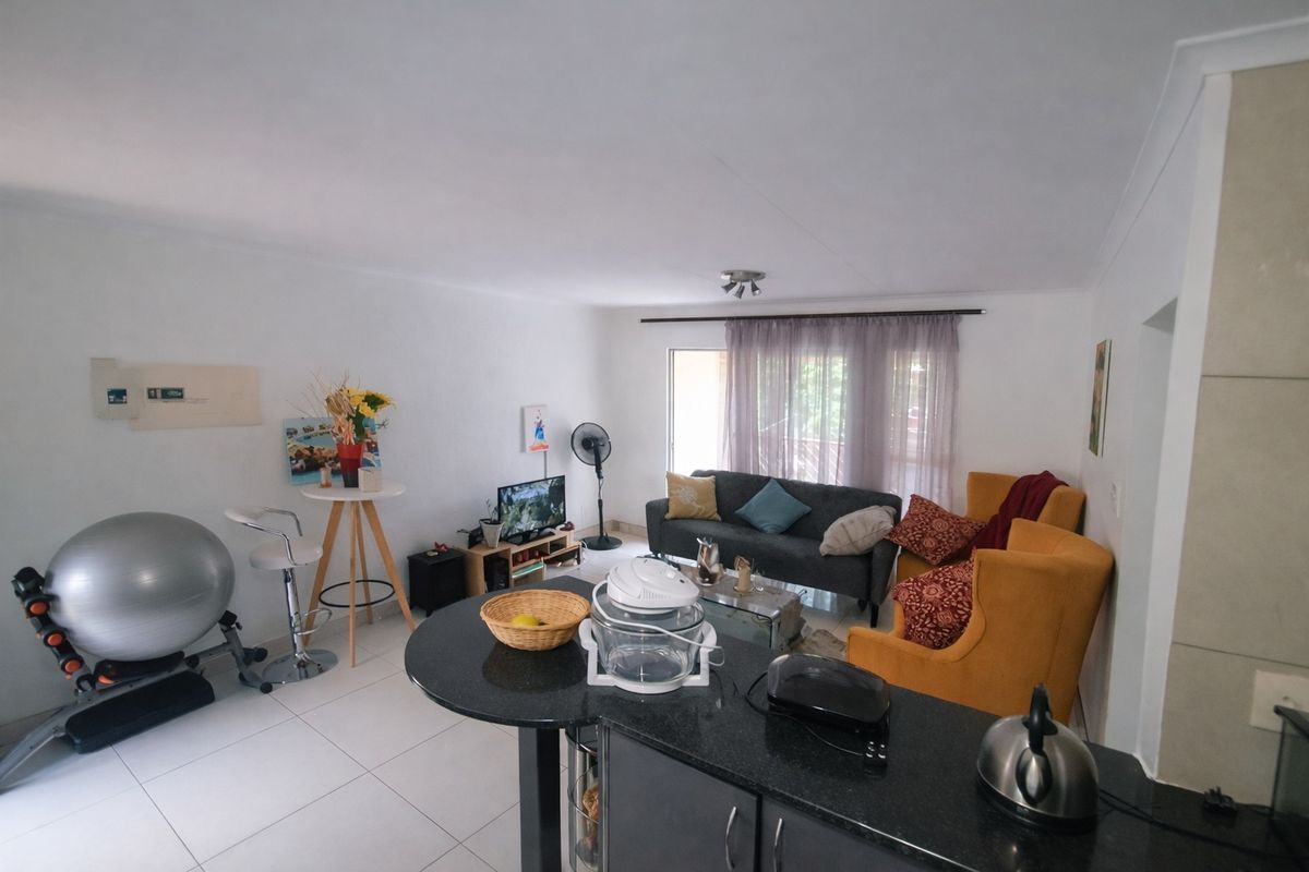 Open-plan living area featuring tiled floors and a kitchen with granite countertops, providing a functional and connected space for daily living.