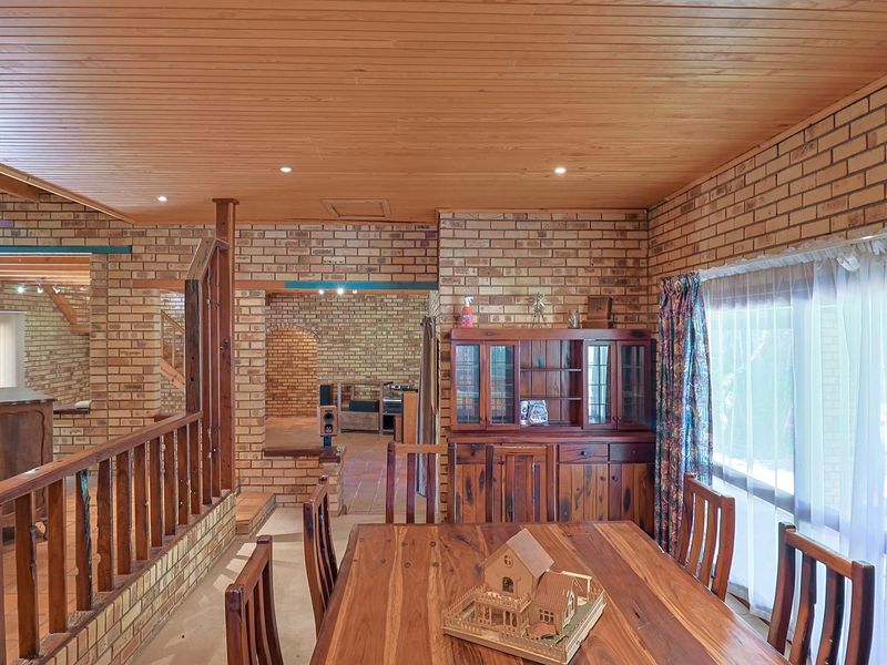 A dining area featuring exposed brick walls, a warm timber-paneled ceiling, and terracotta flooring, creating a rustic and traditional atmosphere.