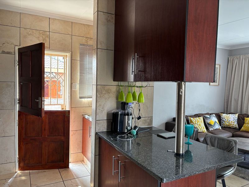 Open plan living area featuring a kitchen with granite countertops, dark wood cabinetry, and a stable door leading to the exterior.