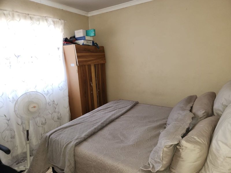 A compact bedroom featuring a built-in wardrobe and neutral wall finishes, offering a functional space ready for cosmetic updates.