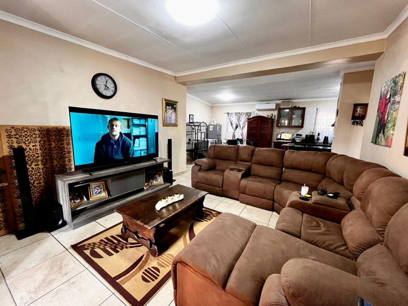 Open-plan living area featuring tiled flooring and an integrated kitchen space, providing a functional and connected layout for daily living.