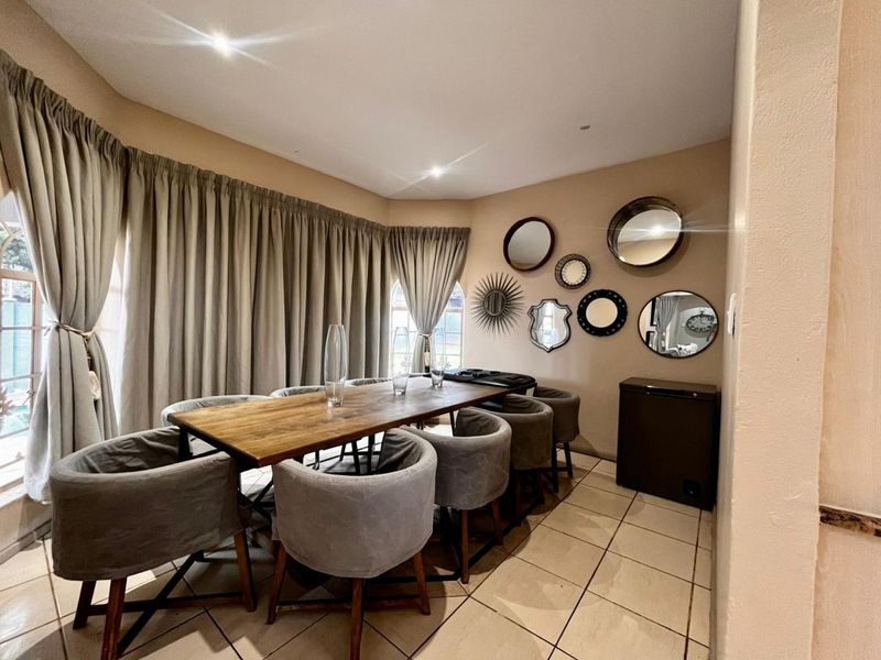 A dining room featuring tiled flooring and recessed downlights, providing a functional space for family meals and entertaining.
