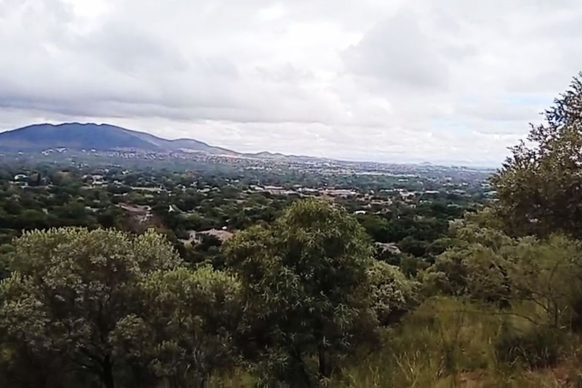 A scenic elevated view overlooking the surrounding landscape, residential area, and distant mountains.