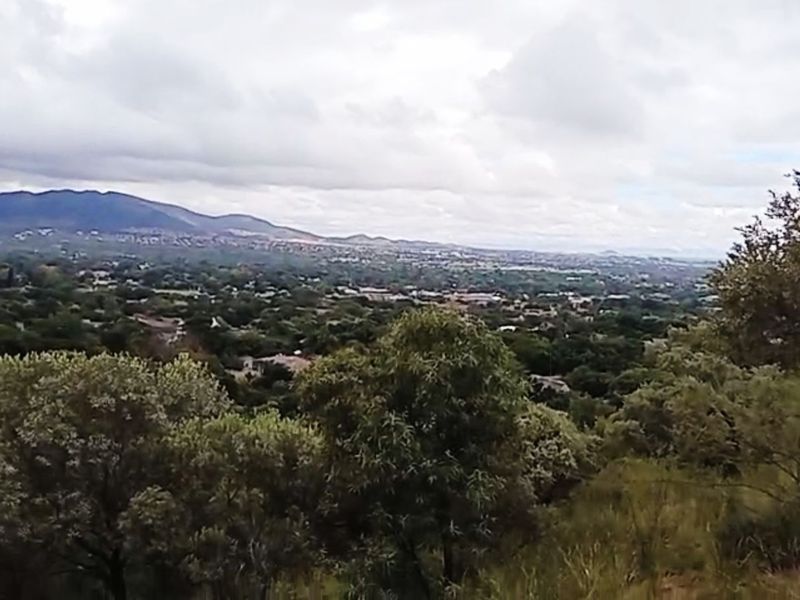 A scenic elevated view overlooking the surrounding landscape, residential area, and distant mountains.