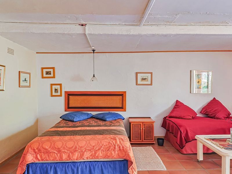 A bedroom featuring terracotta floor tiles and an exposed beam ceiling, requiring cosmetic updates to improve the overall finish and aesthetic appeal.
