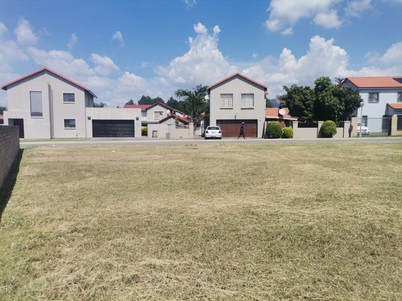 A clear, level vacant residential plot of land situated in a developed suburban neighborhood.