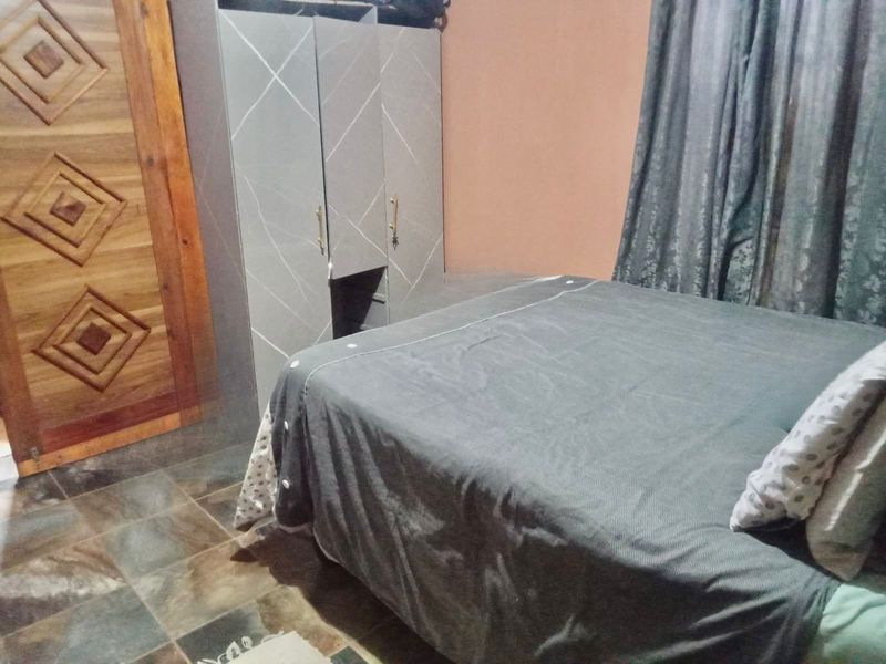 A bedroom featuring tiled flooring and a decorative wooden door.