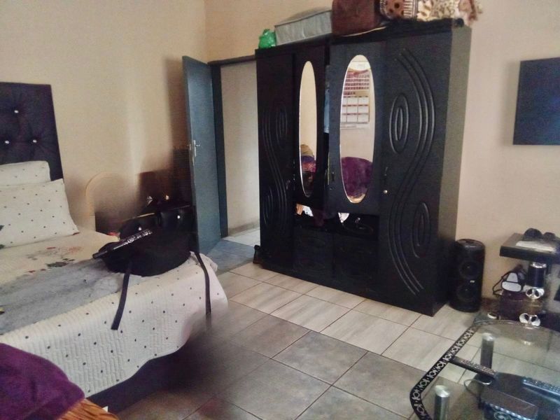 A bedroom featuring tiled flooring and a standard internal door, providing a functional living space.