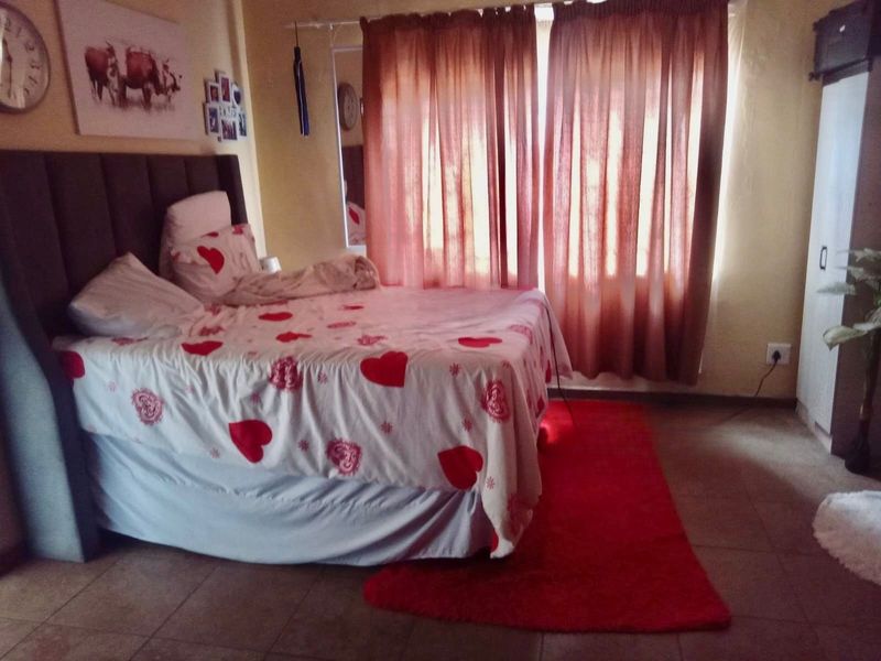 A standard bedroom featuring tiled flooring and a built-in wardrobe, providing a functional living space.