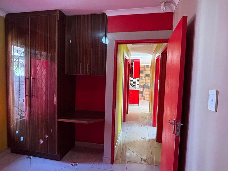 A hallway featuring tiled flooring and built-in cabinetry, providing access to other rooms within the home.