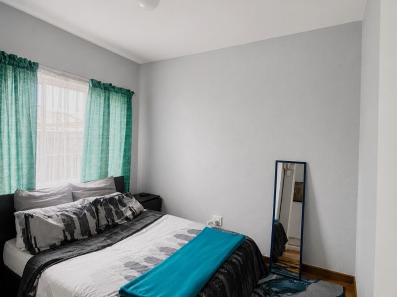 A functional bedroom featuring a window with natural light and standard electrical fixtures.