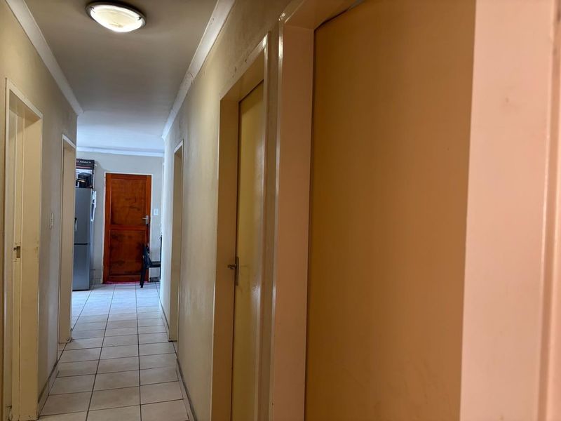 A functional hallway featuring tiled flooring and multiple internal doors, providing access to various rooms within the home.