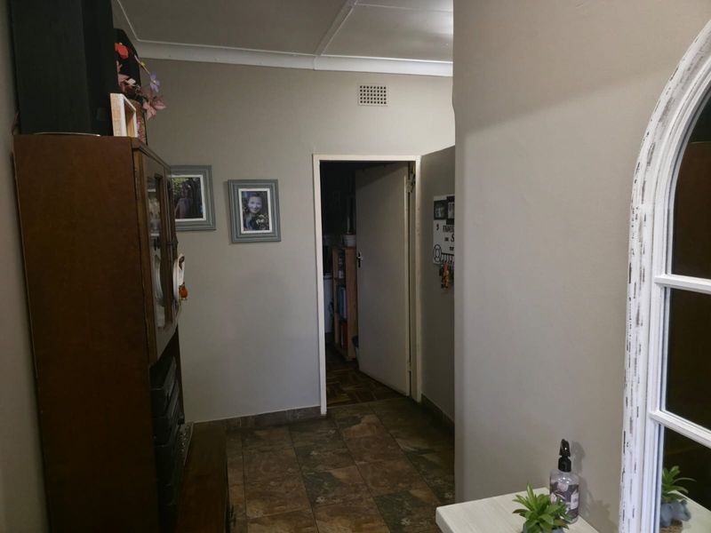 A functional hallway featuring tiled flooring and neutral wall tones, providing access to adjacent rooms within the home.