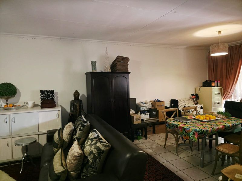 Open plan living and dining area featuring tiled flooring and a neutral wall finish, providing a versatile space for daily living.
