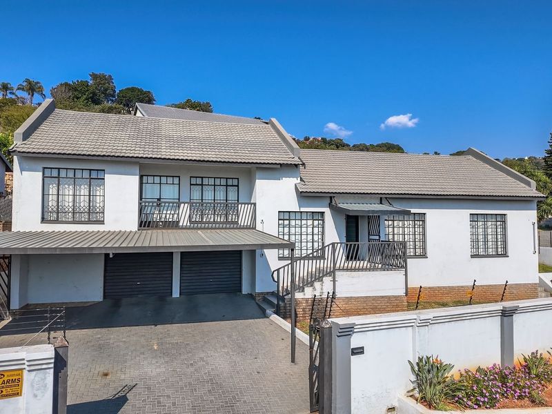 A well-maintained double-story residence featuring a tiled roof, double garage, carport, and secure perimeter walling with electric fencing.