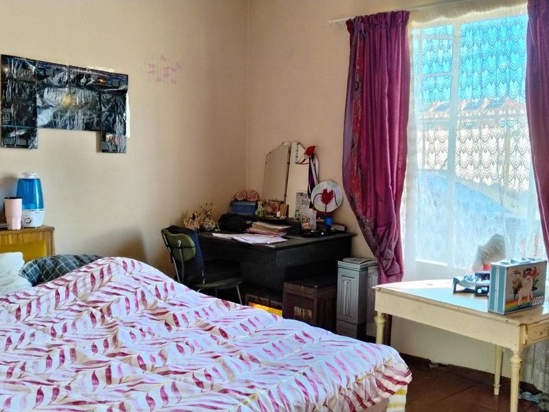 A bedroom featuring a window with curtains, providing natural light and a functional layout for a sleeping area.