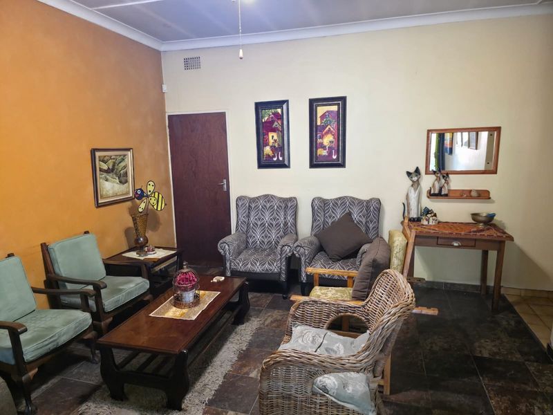 A living room featuring tiled flooring and a coved ceiling, offering a functional space with potential for modern updates.
