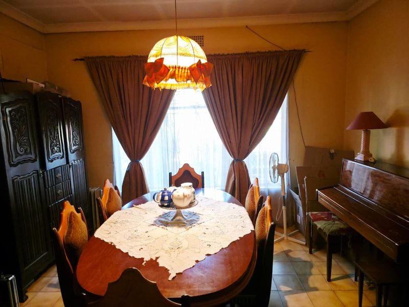 A traditional dining room featuring tiled flooring and a central ceiling light fixture, offering a functional space for family meals.