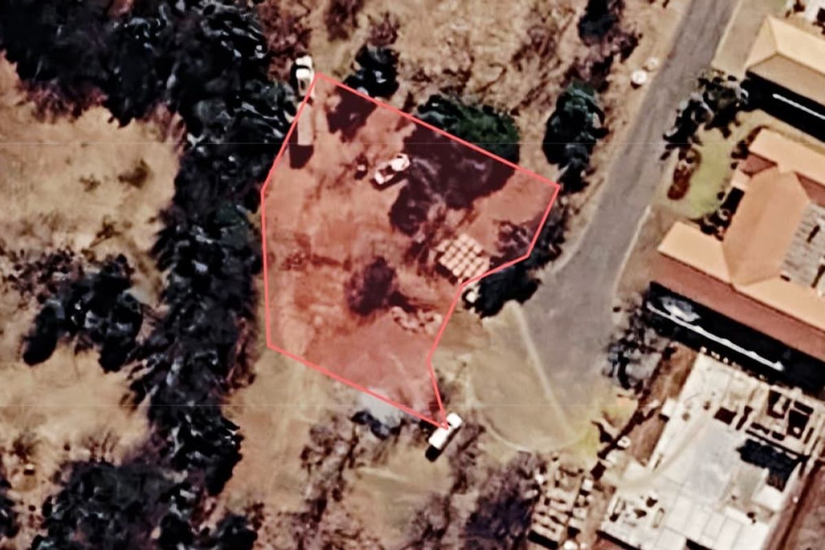 An aerial view of a vacant residential plot showing the property boundaries and surrounding landscape.