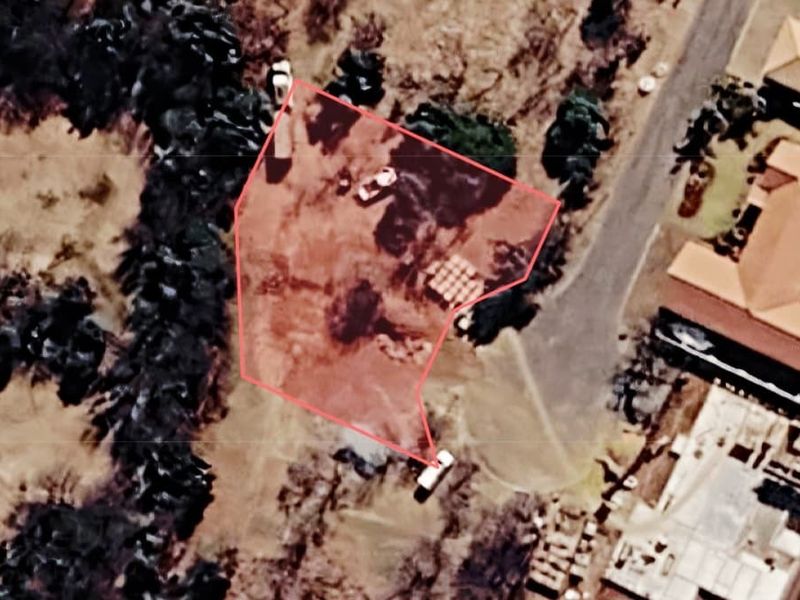 An aerial view of a vacant residential plot showing the property boundaries and surrounding landscape.