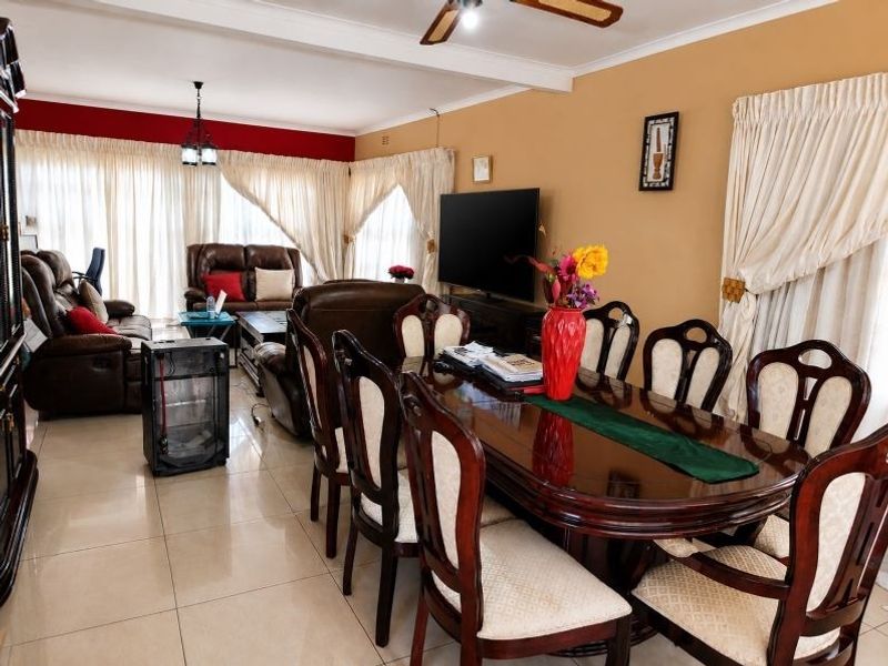 Spacious open-plan living and dining area featuring tiled flooring, ceiling fan, and neutral wall finishes, providing a versatile layout for family living.