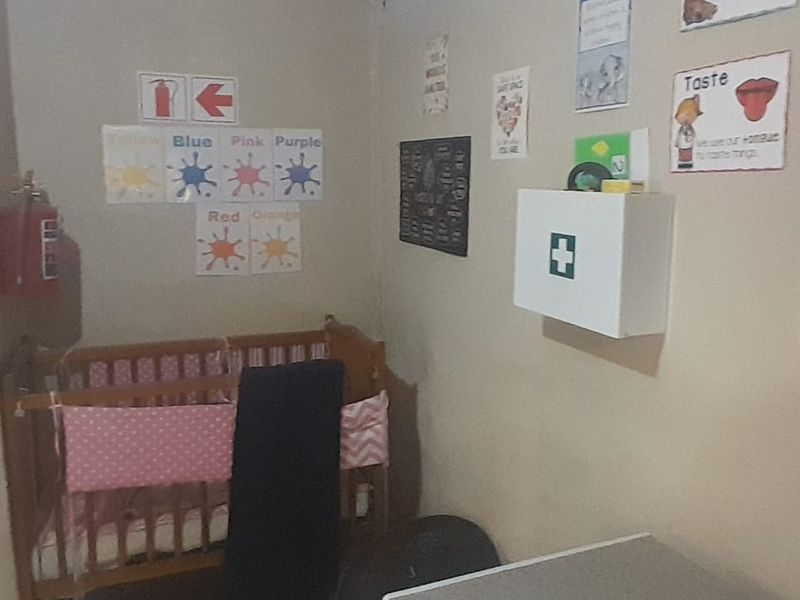 A small bedroom space currently utilized with educational wall decor, featuring a wall-mounted first aid cabinet and fire safety equipment.