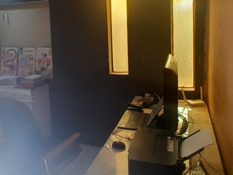 A small home office space featuring a built-in desk and vertical windows, currently used as a workspace.