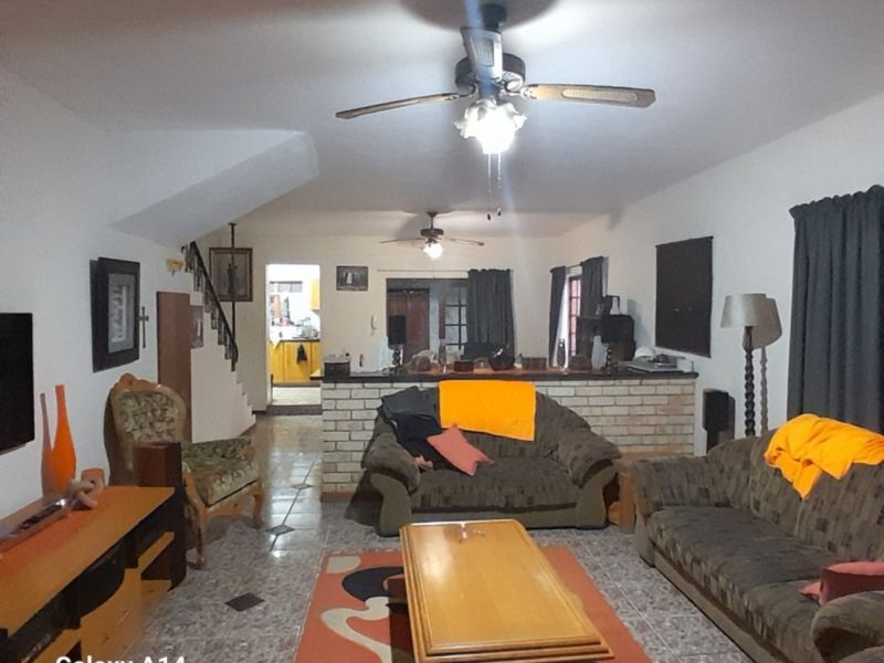 Open plan living area featuring tiled flooring, a brick breakfast bar, and a staircase leading to the upper level.
