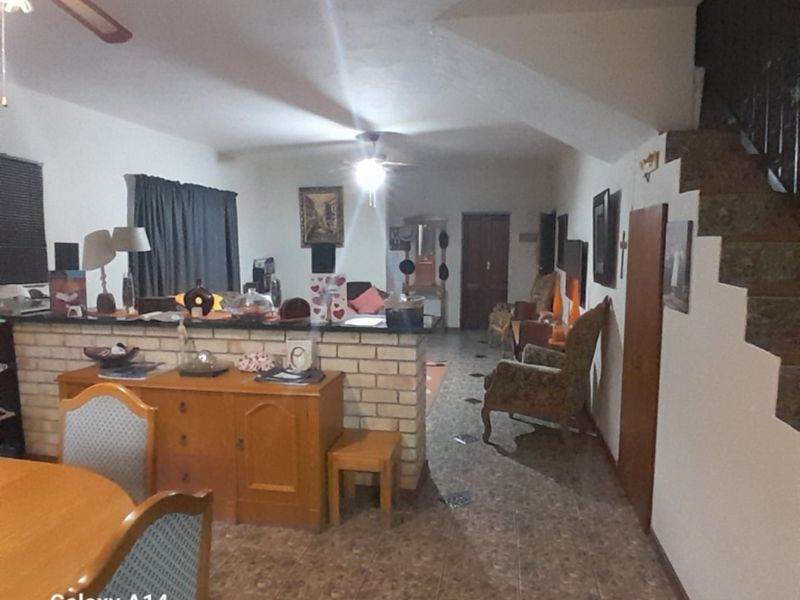 Open plan living area featuring a brick breakfast bar, tiled flooring, and an internal staircase leading to the upper level.