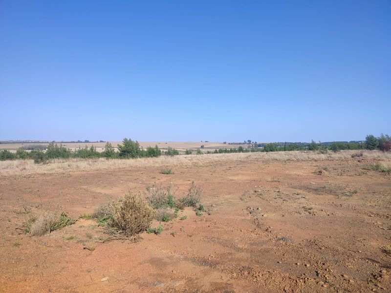 A wide-angle view of the vacant residential land, showcasing the natural terrain and open landscape.