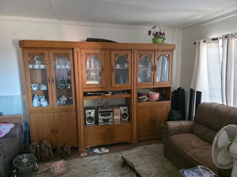 Living room featuring a large, traditional built-in wooden wall unit with glass display cabinets and storage cupboards.