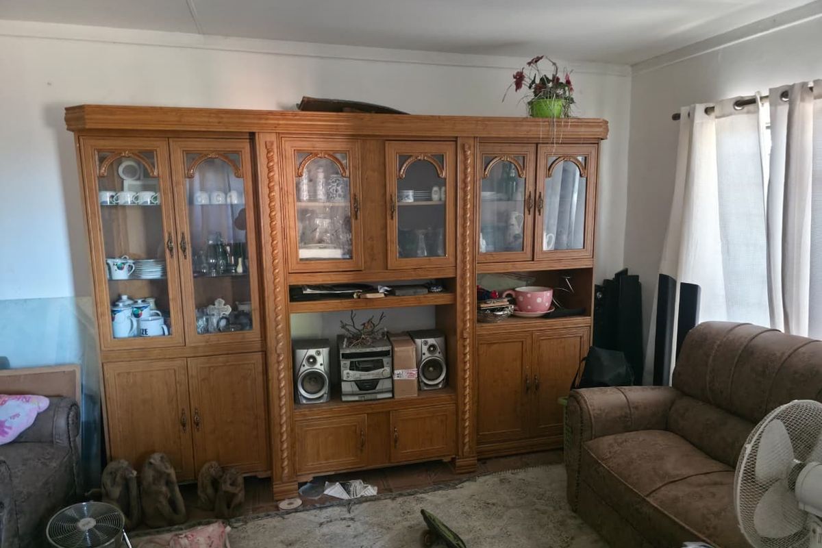 Living room featuring a large, traditional built-in wooden wall unit with glass display cabinets and storage cupboards.